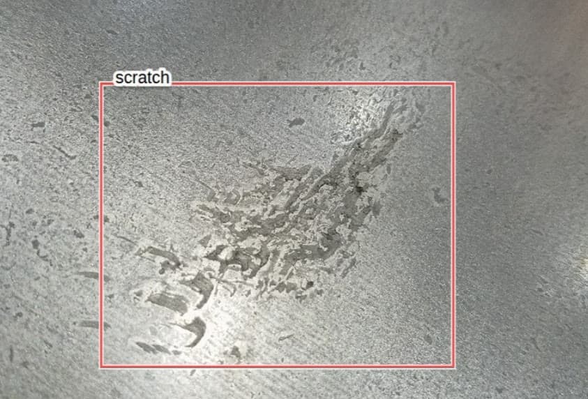 A scratch on a metal surface, boxed and classified by the model.